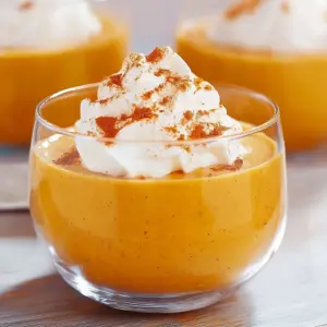 Delicious homemade pumpkin pudding served in a bowl, garnished with whipped cream