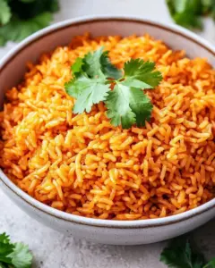 Bowl of Simple Mexican Rice garnished with cilantro and lime